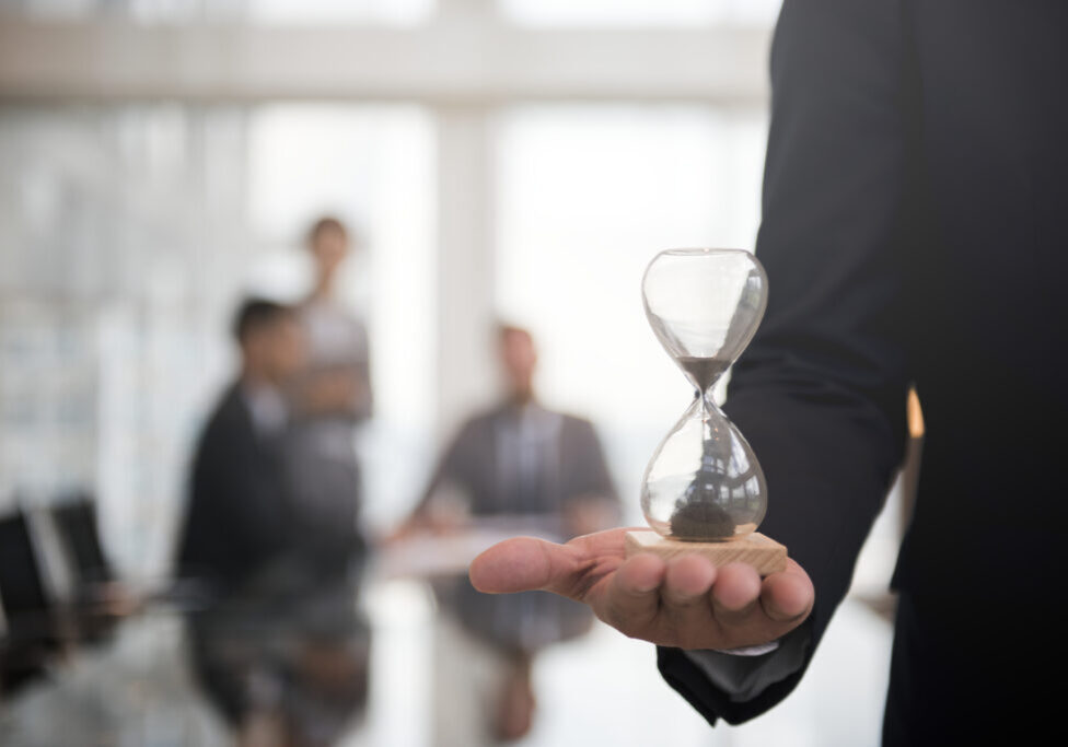 Businessman holding an hour glass, signifies the importance of being on time